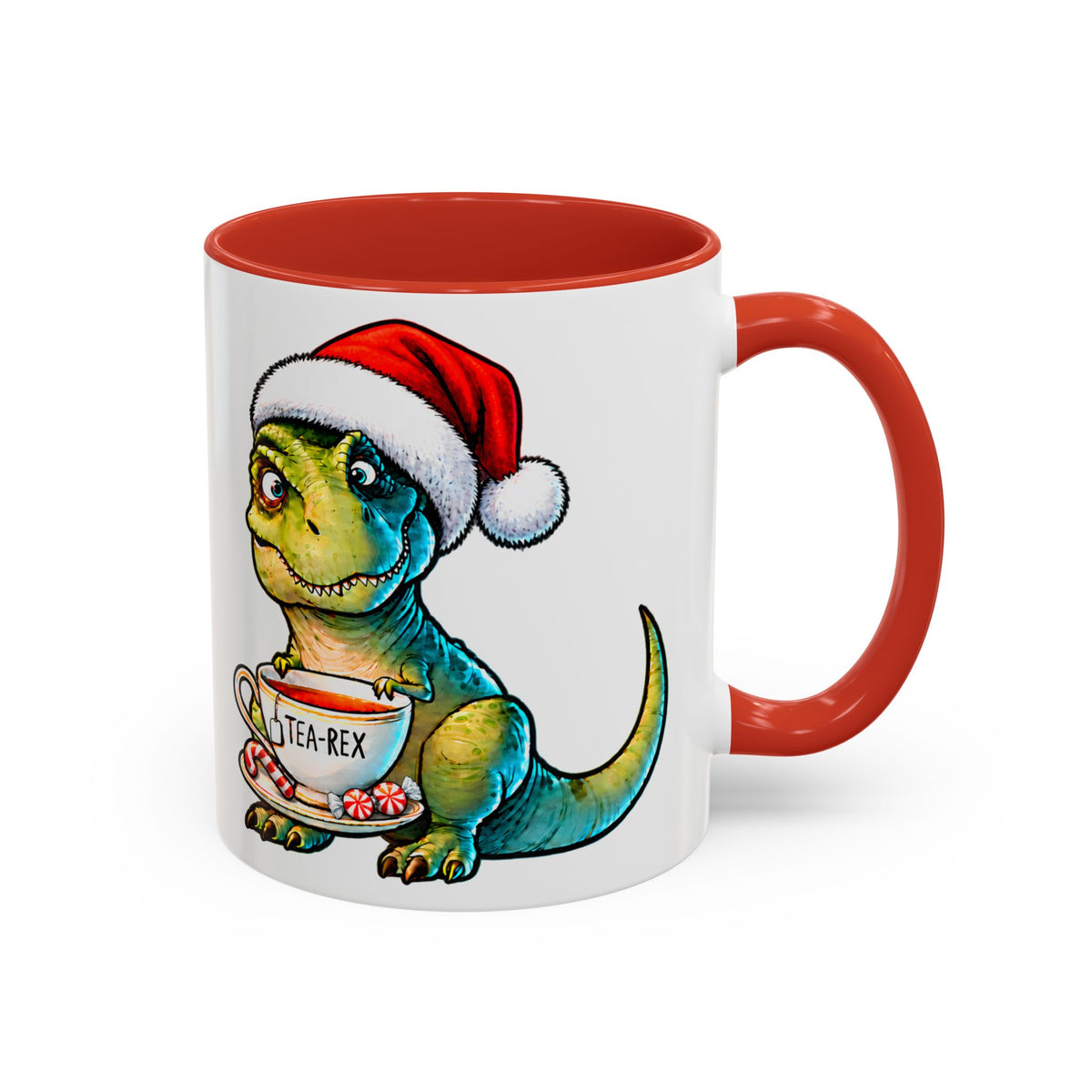 Kırmızı kulplu ve kırmızı iç yüzeyli beyaz porselen kupada, Noel şapkası takan Tea-Rex dinozoru; önünde “TEA-REX” yazılı fincan, baston şeker ve naneli şekerler.